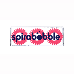A flat transparent box of 3 candy pink coloured hair accessories called spirabobbles