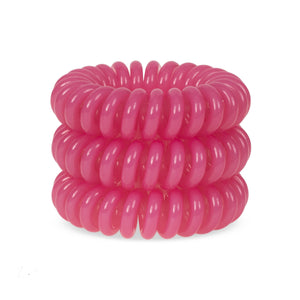 A tower of 3 candy pink coloured hair bobbles called spirabobbles. A plastic spiral circular hair tie spira bobble.