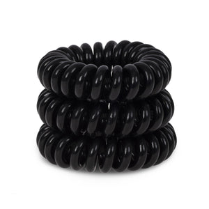 A tower of 3 black magic coloured hair bobbles called spirabobble. A black plastic spiral circular hair tie spira bobble.