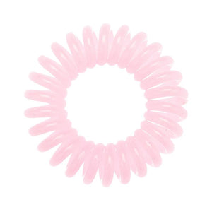 A baby pink coloured plastic spiral circular hair bobble on a white background called a spirabobble.
