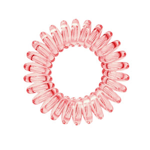 A barely red coloured plastic spiral circular hair bobble on a white background called a spirabobble.