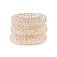 Load image into Gallery viewer, A tower of 3 honey yellow coloured hair bobbles called spirabobbles. A beige plastic spiral circular hair tie spira bobble.
