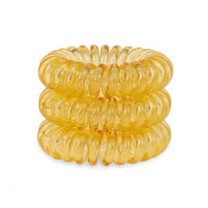 A tower of 3 mellow yellow coloured hair bobbles called spirabobbles. A yellow plastic spiral circular hair tie spira bobble.