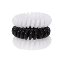 Load image into Gallery viewer, A tower of 3 black and white coloured hair bobbles called spirabobbles. A plastic spiral circular hair tie spira bobble.
