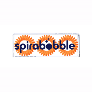 A flat transparent box of 3 Tangerine Orange coloured hair accessories called spirabobbles.