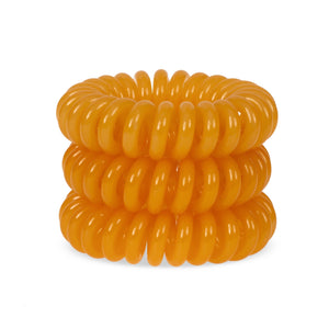 A tower of 3 Tangerine Orange coloured hair bobbles called spirabobbles. A plastic spiral circular hair tie spira bobble.