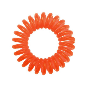 A bright orange coloured plastic spiral circular hair bobble on a white background called a spirabobble.