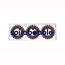 Load image into Gallery viewer, A flat transparent box of 3 brown sugar coloured hair accessories called spirabobbles
