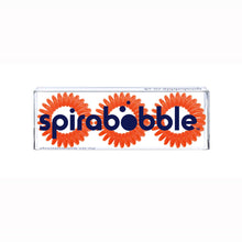 Load image into Gallery viewer, A flat transparent box of 3 bright orange coloured hair accessories called spirabobbles
