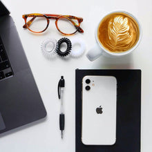 Load image into Gallery viewer, Aerial picture of a desk with laptop, iphone, notepad, a latte coffee, brown specs and a black spirabobble
