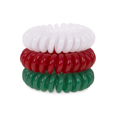 A tower of three (placed on top of each other) of white, red and green coloured plastic spiral circular hair bobbles on a white background that looks like an old fashioned curly coiled telephone cable or a coiled spring which has been made into a circular