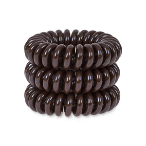 A tower of 3 brown sugar coloured hair bobbles called spirabobbles. A plastic spiral circular hair tie spira bobble.