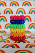 Load image into Gallery viewer, A tower of different coloured hair bobbles called spirabobbles which make up the colours of a rainbow. A black plastic spiral circular hair tie spira bobble.
