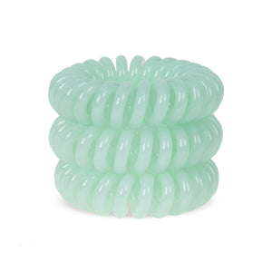 A tower of 3 always aqua green coloured hair bobbles called spirabobble. A plastic spiral circular hair tie spira bobble.