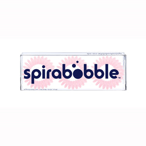 A flat transparent box of 3 baby pink coloured hair accessories called spirabobble
