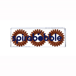 A flat transparent box of 3 cinnamon bun brown coloured hair accessories called spirabobbles