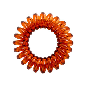 An amber brown coloured plastic spiral circular hair bobble on a white background called a spirabobble