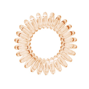 A honey yellow coloured plastic spiral circular hair bobble on a white background called a spirabobble.