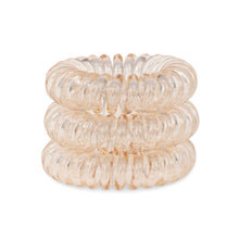 Load image into Gallery viewer, A tower of 3 honey yellow coloured hair bobbles called spirabobbles. A beige plastic spiral circular hair tie spira bobble.
