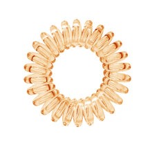 Load image into Gallery viewer, A light orange coloured plastic spiral circular hair bobble on a white background called a spirabobble.

