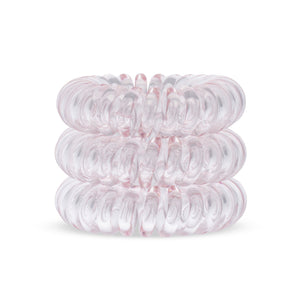 A tower of 3 light pink coloured hair bobbles called spirabobbles. A Pink plastic spiral circular hair tie spira bobble.