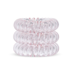 A tower of 3 light pink coloured hair bobbles called spirabobbles. A Pink plastic spiral circular hair tie spira bobble.