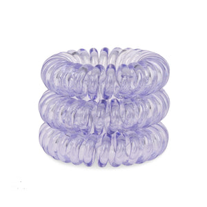 A tower of three (placed on top of each other) transparent navy blue coloured plastic spiral circular hair bobbles on a white background that looks like an old fashioned curly coiled telephone cable or a coiled spring which has been made into a circle