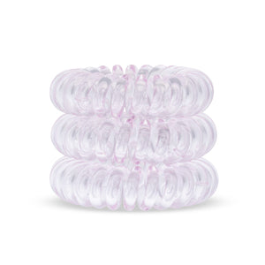 A tower of 3 perfect pink coloured hair bobbles called spirabobbles. A plastic spiral circular hair tie spira bobble.