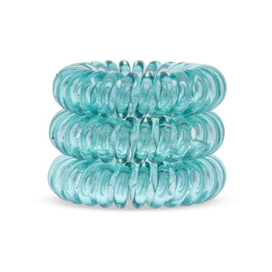 A tower of 3 pine green coloured hair bobbles called spirabobbles. A plastic spiral circular hair tie spira bobble.