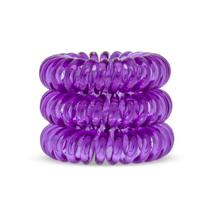 A tower of 3 purple berry coloured hair bobbles called spirabobbles. A purple plastic spiral circular hair tie spira bobble.