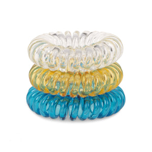 A tower of 3 different coloured hair bobbles called spirabobbles. A plastic spiral circular hair tie spira bobble.