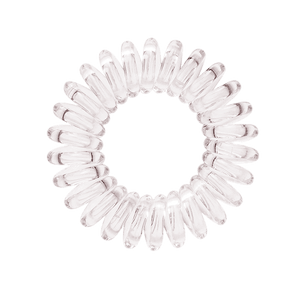 A see through clear coloured plastic circular hairband on a white background that looks like an old fashioned curly coiled telephone cable or a coiled spring which has been made into a circular shape