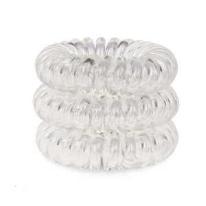 A tower of 3 transparent clear coloured hair bobbles called spirabobbles. A clear plastic spiral circular hair tie spira bobble.