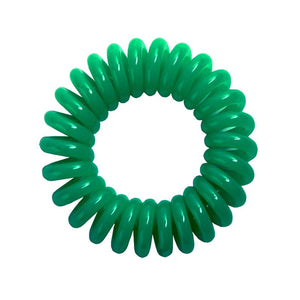 A green coloured plastic spiral circular hair bobble on a white background called a spirabobble.
