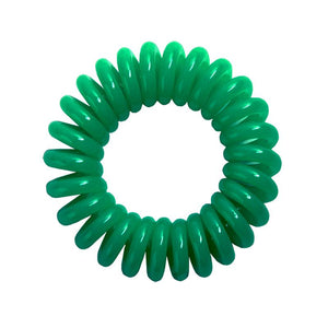 A green coloured plastic spiral circular hair bobble on a white background called a spirabobble.