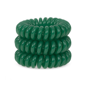 A tower of 3 green dream coloured hair bobbles called spirabobbles. A green plastic spiral circular hair tie spira bobble.
