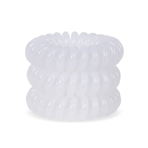A tower of 3 ice white coloured hair bobbles called spirabobbles. A white plastic spiral circular hair tie spira bobble.