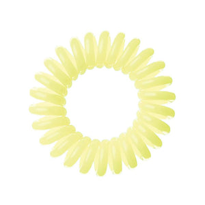 A pale yellow lemon pie coloured plastic spiral circular hair bobble on a white background called a spirabobble.