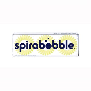 A flat transparent box of 3 pale yellow lemon pie coloured hair accessories called spirabobbles