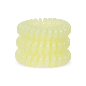 A tower of 3 pale yellow lemon pie coloured hair bobbles called spirabobbles. A lemon yellow plastic spiral circular hair tie spira bobble.