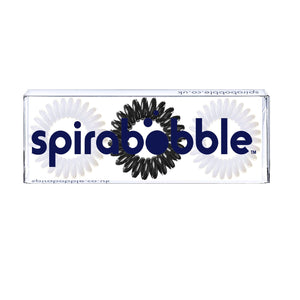 A flat transparent box of 2 white and 1 black coloured hair accessories called spirabobbles