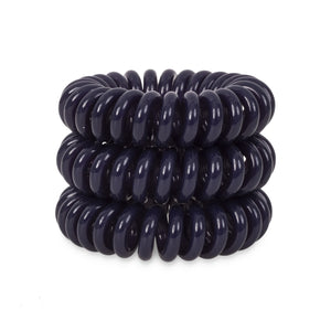 A tower of 3 navy blue coloured hair bobbles called spirabobbles. A plastic spiral circular hair tie spira bobble.