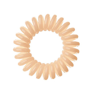 A Perfectly Peach coloured plastic spiral circular hair bobble on a white background called a spirabobble.