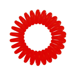 A red coloured plastic spiral circular hair bobble on a white background called a spirabobble.
