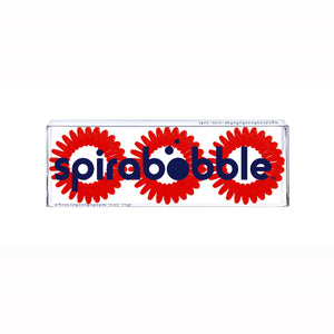 A flat transparent box of 3 red coloured hair accessories called spirabobbles