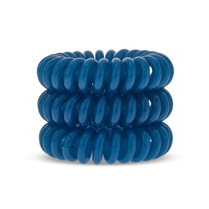 A tower of three (placed on top of each other) turquoise blue solid coloured plastic spiral circular hair bobbles on a white background that looks like an old fashioned curly coiled telephone cable or a coiled spring which has been made into a circular sh